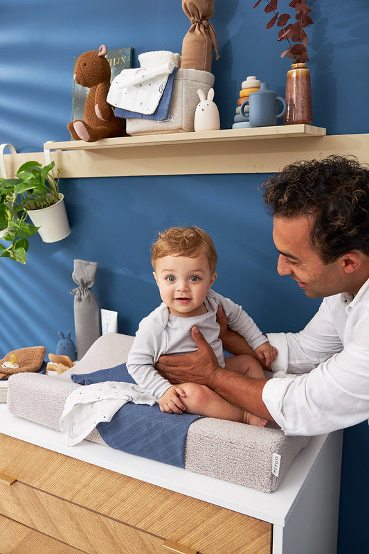 Baby sitting on the Meyco changing pad cover teddy greige color