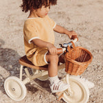 Boy riding the Banwood Trike Cream