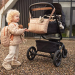 a kid with Jollein Buggy Organizer Puffed Biscuit hanging on a buggy