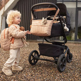 a kid with Jollein Buggy Organizer Puffed Biscuit hanging on a buggy