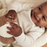 baby holding the Jollein soft play ball in ivory and biscuit