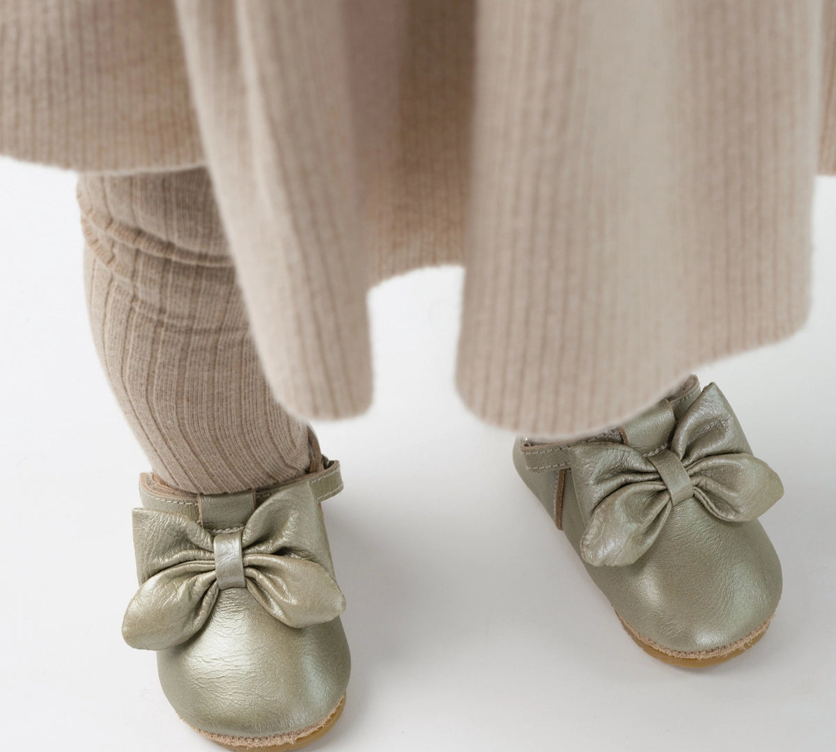 Donsje Celie baby shoes in Champagne Metallic Leather, worn with a beige outfit