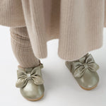 Donsje Celie baby shoes in Champagne Metallic Leather, worn with a beige outfit