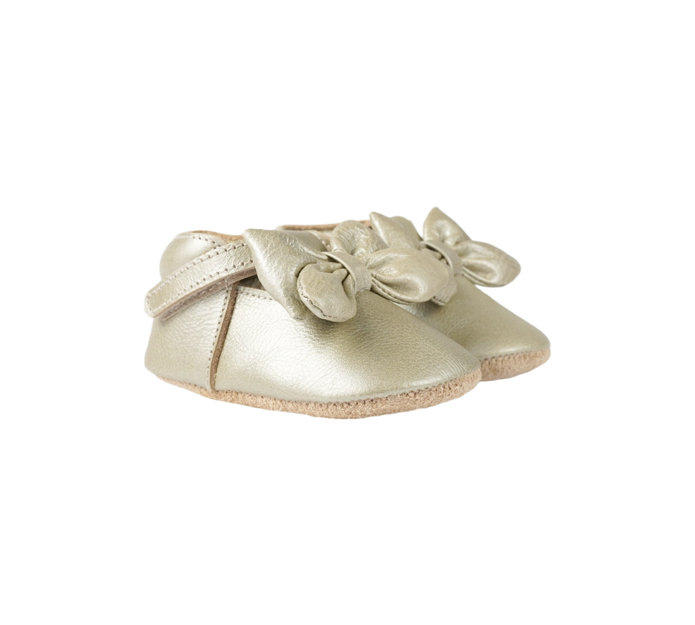 Donsje Celie baby shoes in Champagne Metallic Leather, with bow details, angled front view