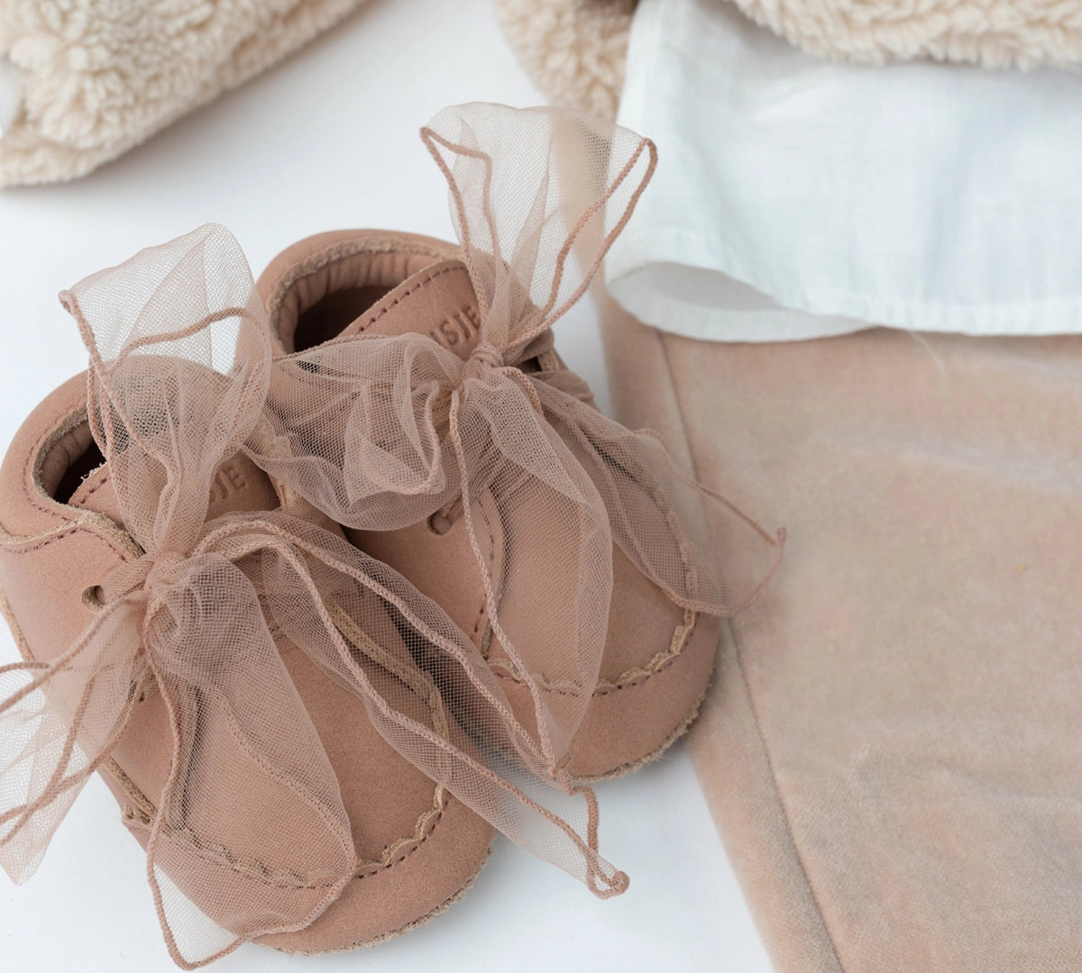 Donsje Lonny baby sneakers in Rose Dawn Classic Leather, with chiffon bows, styled product photograph