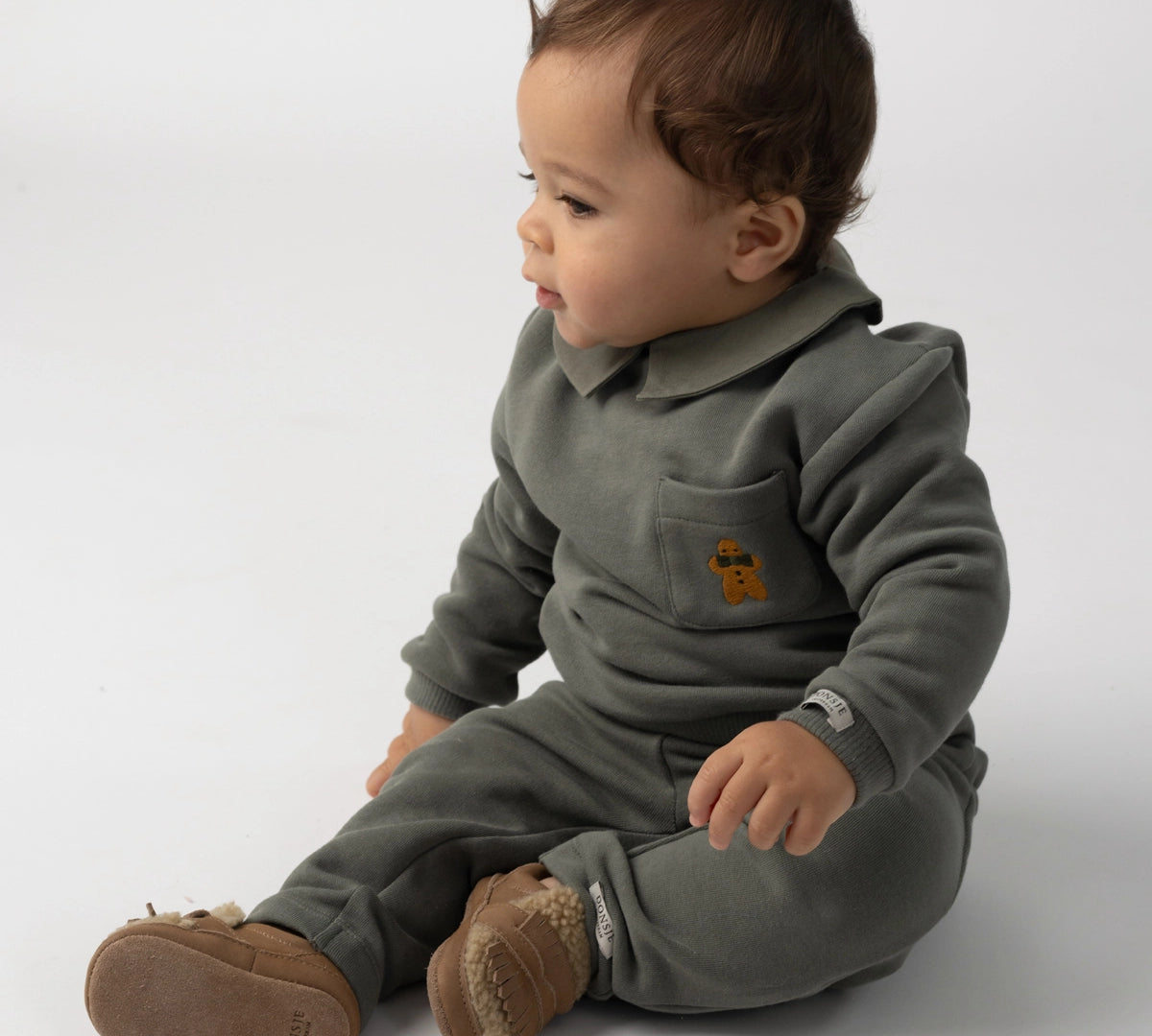 Donsje Nolin baby loafers in Truffle Nubuck, worn by a seated child