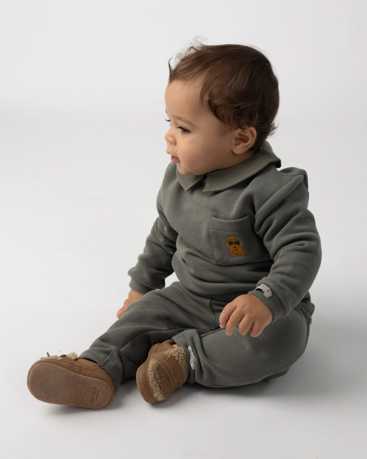 Donsje Nolin baby loafers in Truffle Nubuck, worn by a seated child