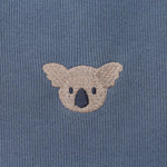 Donsje Phlyn Koalas onesie in Dark Spruce, close-up of an embroidered koala motif