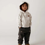 Donsje Kassim Koala trousers in Cloudy Grey, worn by a child with a hooded top