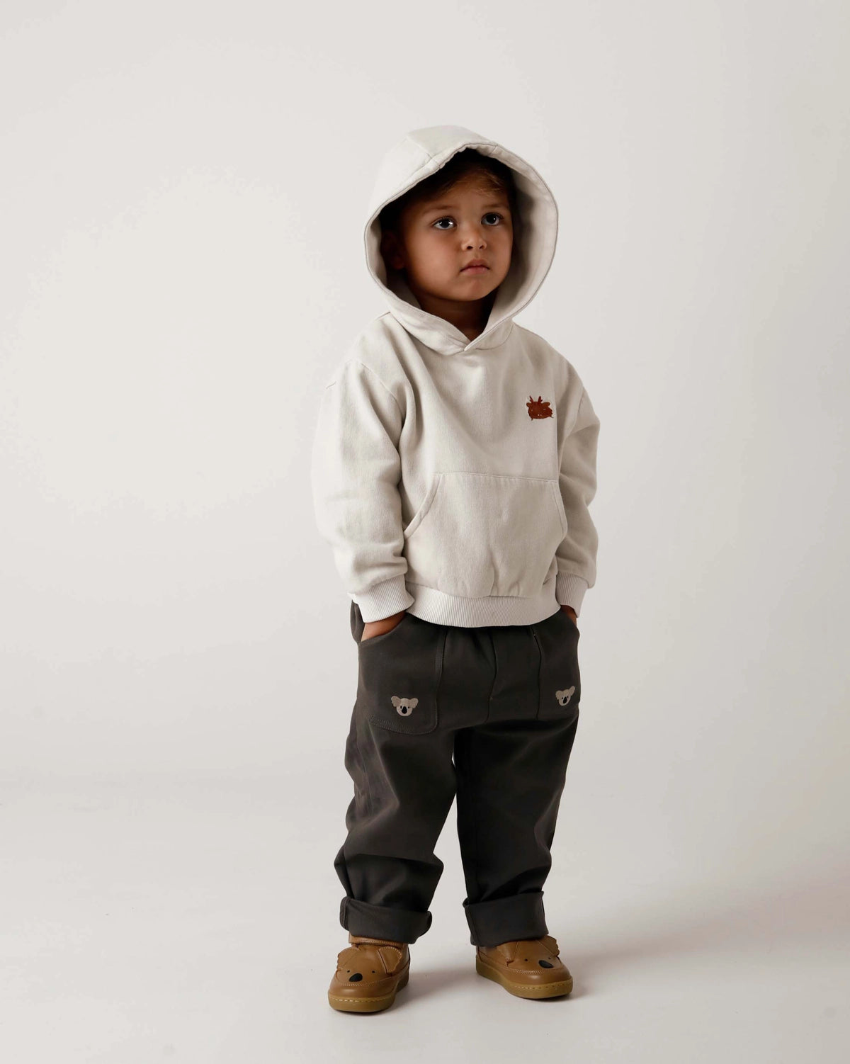 Donsje Kassim Koala trousers in Cloudy Grey, worn by a child with a hooded top