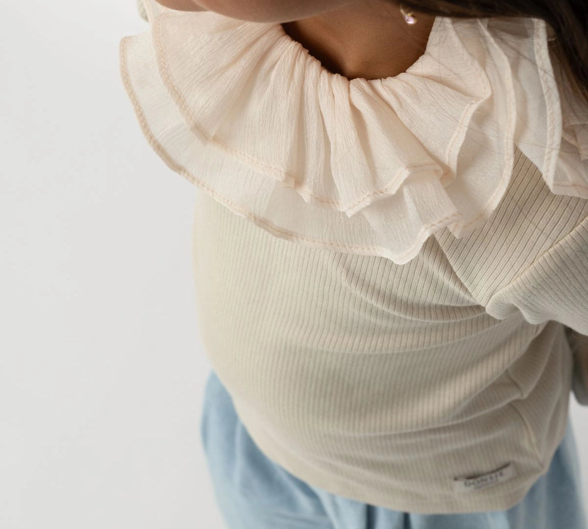 Donsje Florentien top in Birch, worn by a child, close-up of the collar
