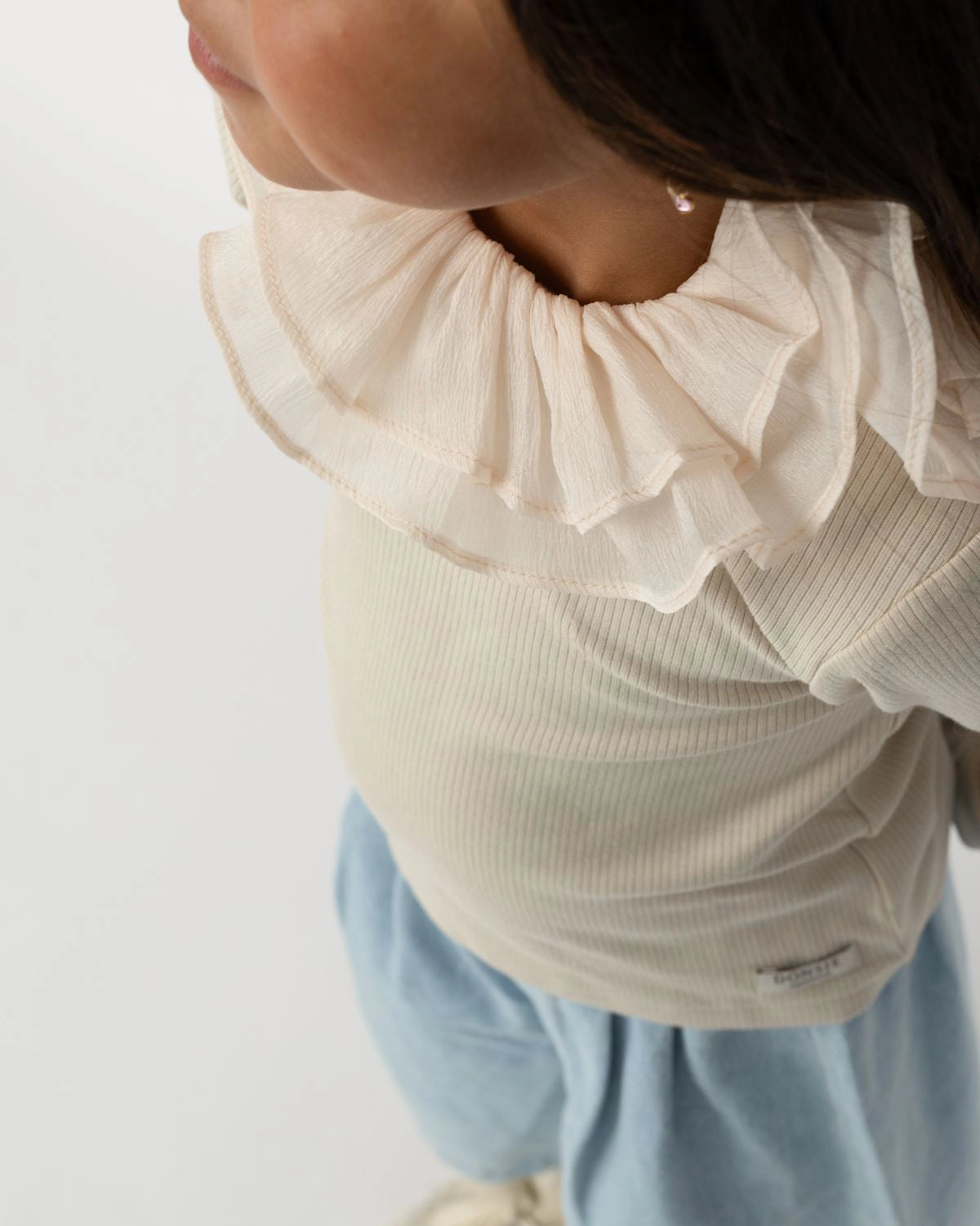 Donsje Florentien top in Birch, worn by a child, close-up of the collar