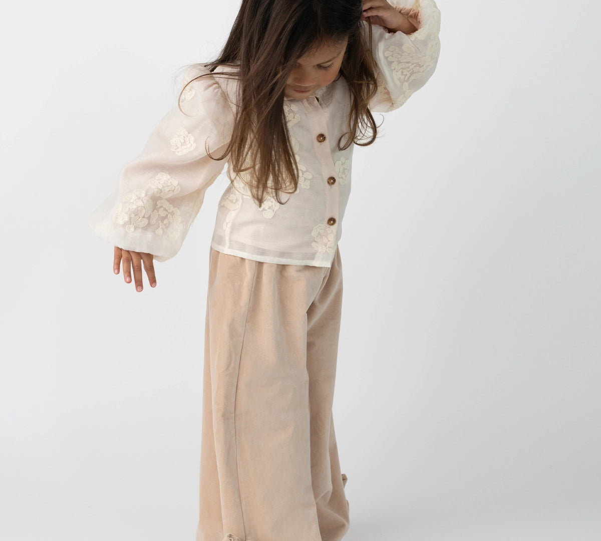 Donsje Nolien Bow trousers in Vintage Rose, worn by a child, angled view