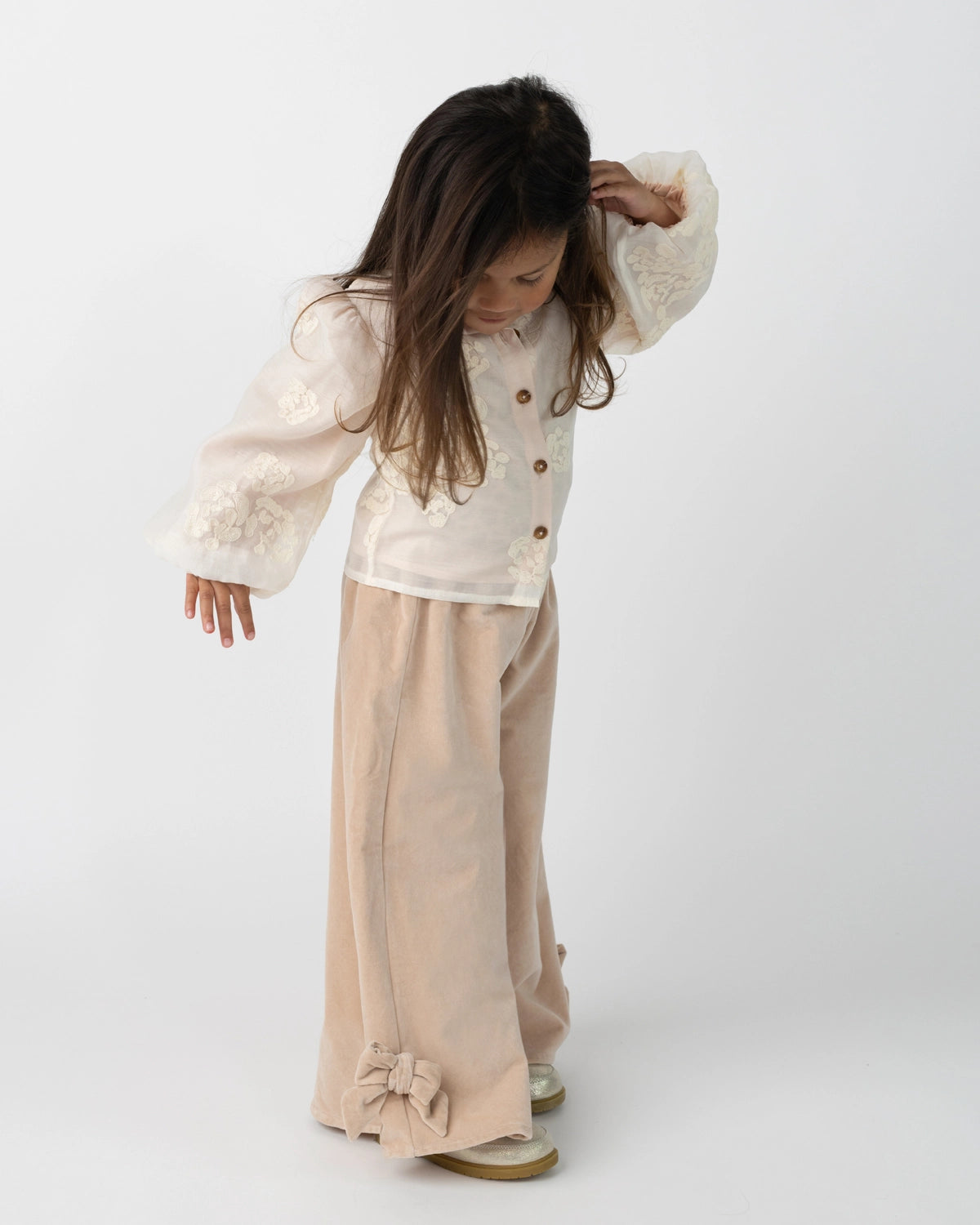 Donsje Nolien Bow trousers in Vintage Rose, worn by a child, angled view