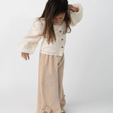 Donsje Nolien Bow trousers in Vintage Rose, worn by a child, angled view