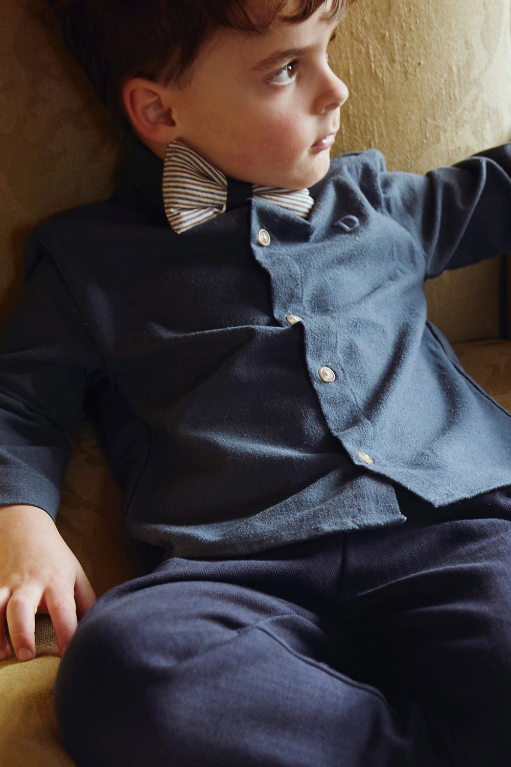 Donsje Chee shirt in Night Blue, worn by a seated child