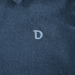 Donsje Chee shirt in Night Blue, close-up of the embroidered D detail