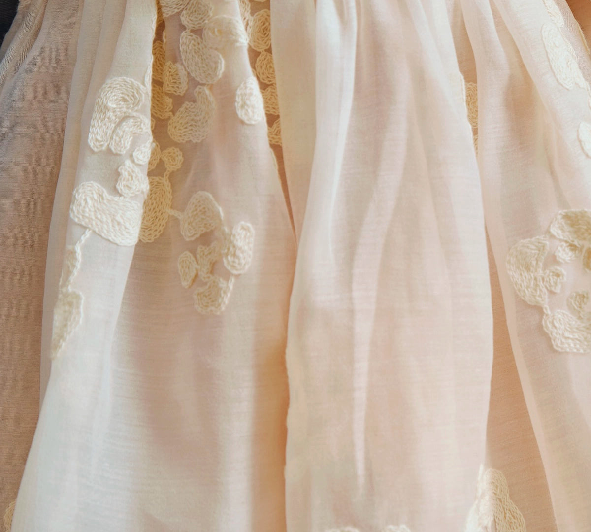Donsje Kylen dress in Soft Powder with White Blossom, worn by a child, close-up of the skirt and floral details