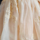 Donsje Kylen dress in Soft Powder with White Blossom, worn by a child, close-up of the skirt and floral details