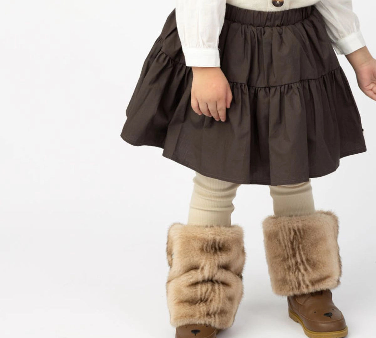 Donsje Azani skirt in Toffee, worn by a child with a cream cardigan and boots