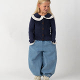 Donsje Dinotje trousers in Sky Blue, worn by a child with a navy cardigan