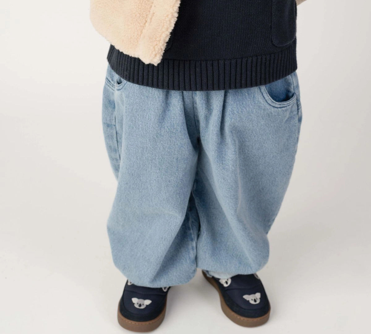 Donsje Dinotje trousers in Sky Blue, worn by a child, close-up of the trousers
