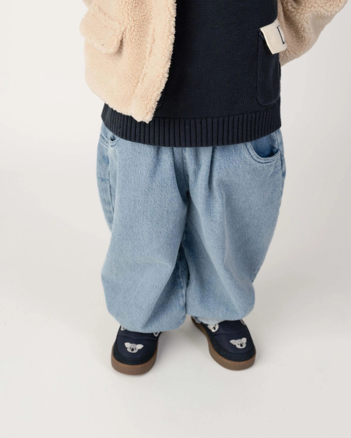 Donsje Dinotje trousers in Sky Blue, worn by a child, close-up of the trousers