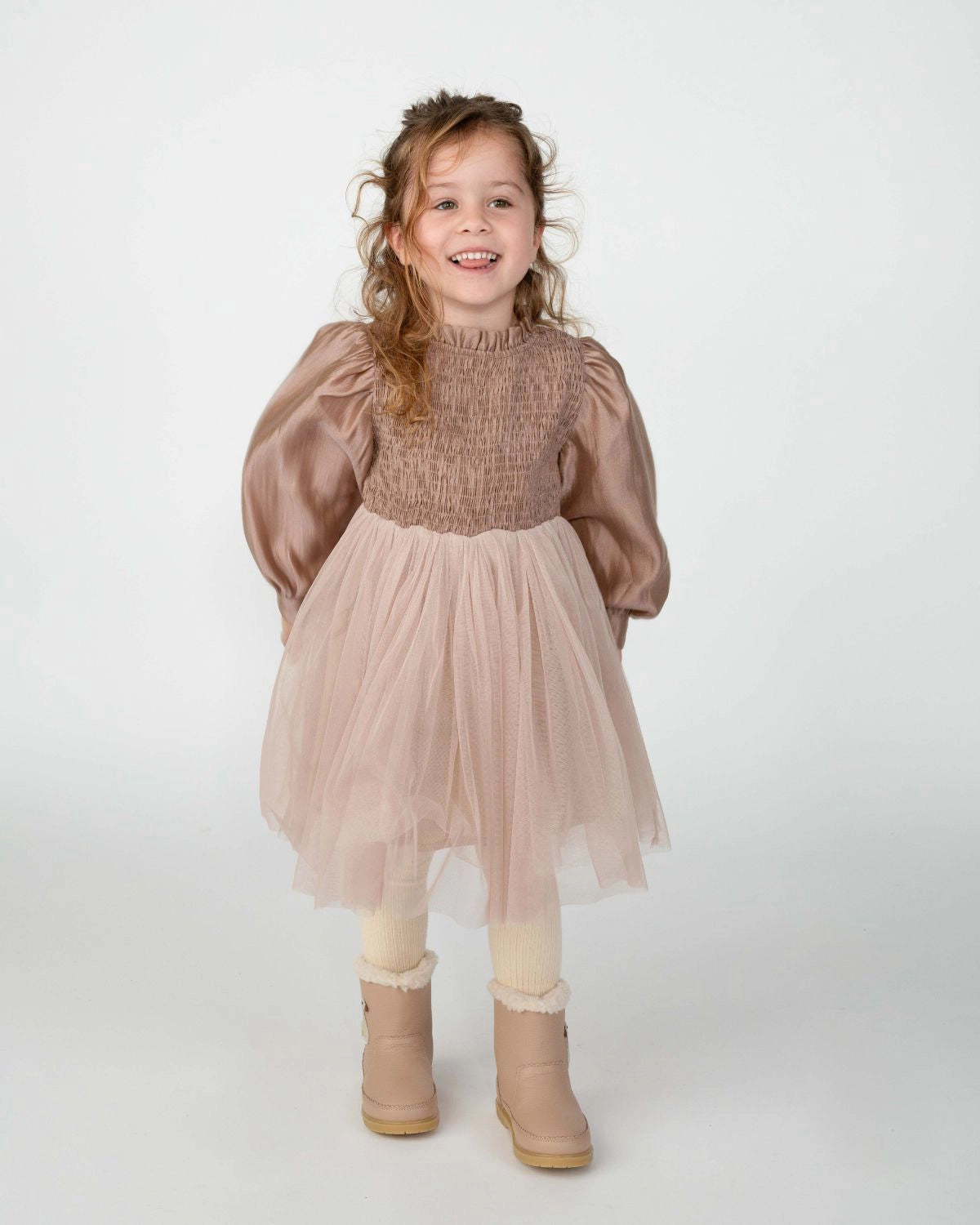 Donsje Janice dress in Rose Brown, worn by a child with beige boots, front view