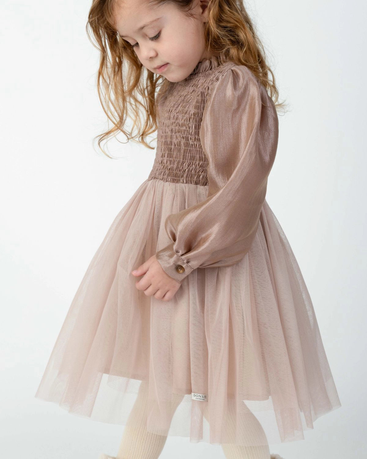 Donsje Janice dress in Rose Brown, worn by a child, angled view