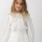 Donsje Kieke blouse in Crispy White, worn by a child with a white skirt