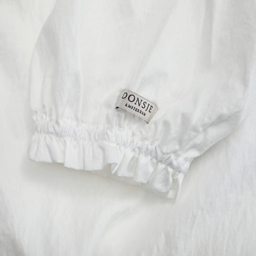 Donsje Kieke blouse in Crispy White, close-up of the ruffled cuff and brand label