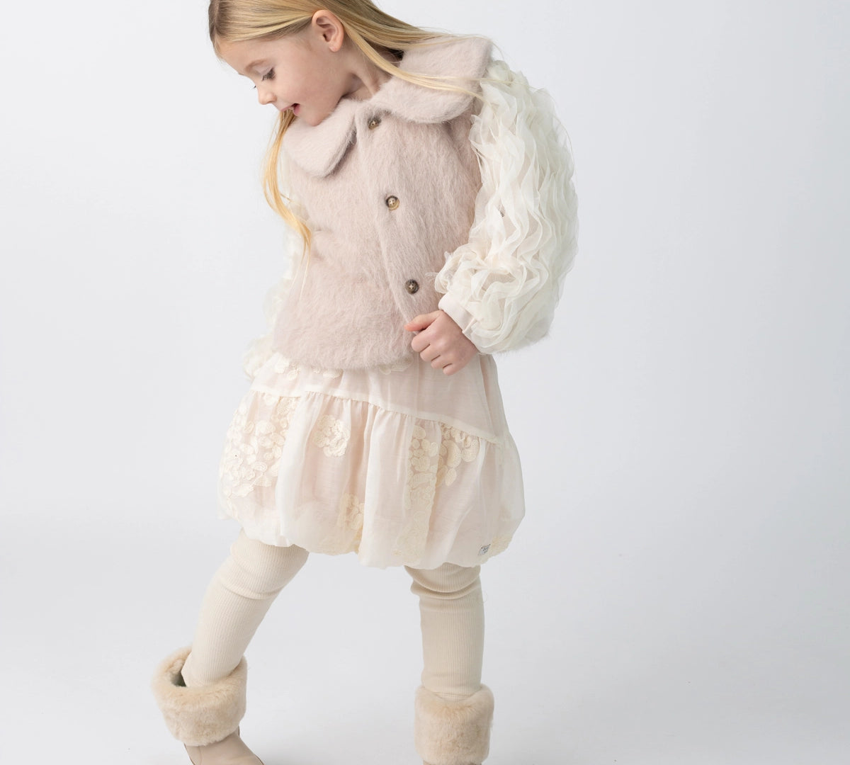 Donsje Kubwa skirt in Soft Powder with White Blossom, worn by a child with a knitted cardigan