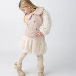 Donsje Kubwa skirt in Soft Powder with White Blossom, worn by a child with a knitted cardigan