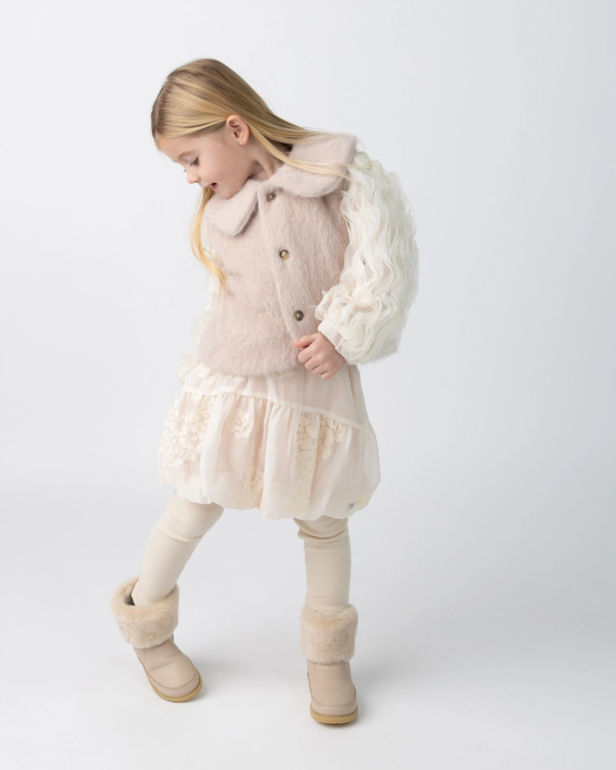 Donsje Kubwa skirt in Soft Powder with White Blossom, worn by a child with a knitted cardigan