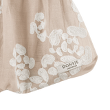Donsje Kubwa skirt in Soft Powder with White Blossom, close-up of the floral hem and brand label