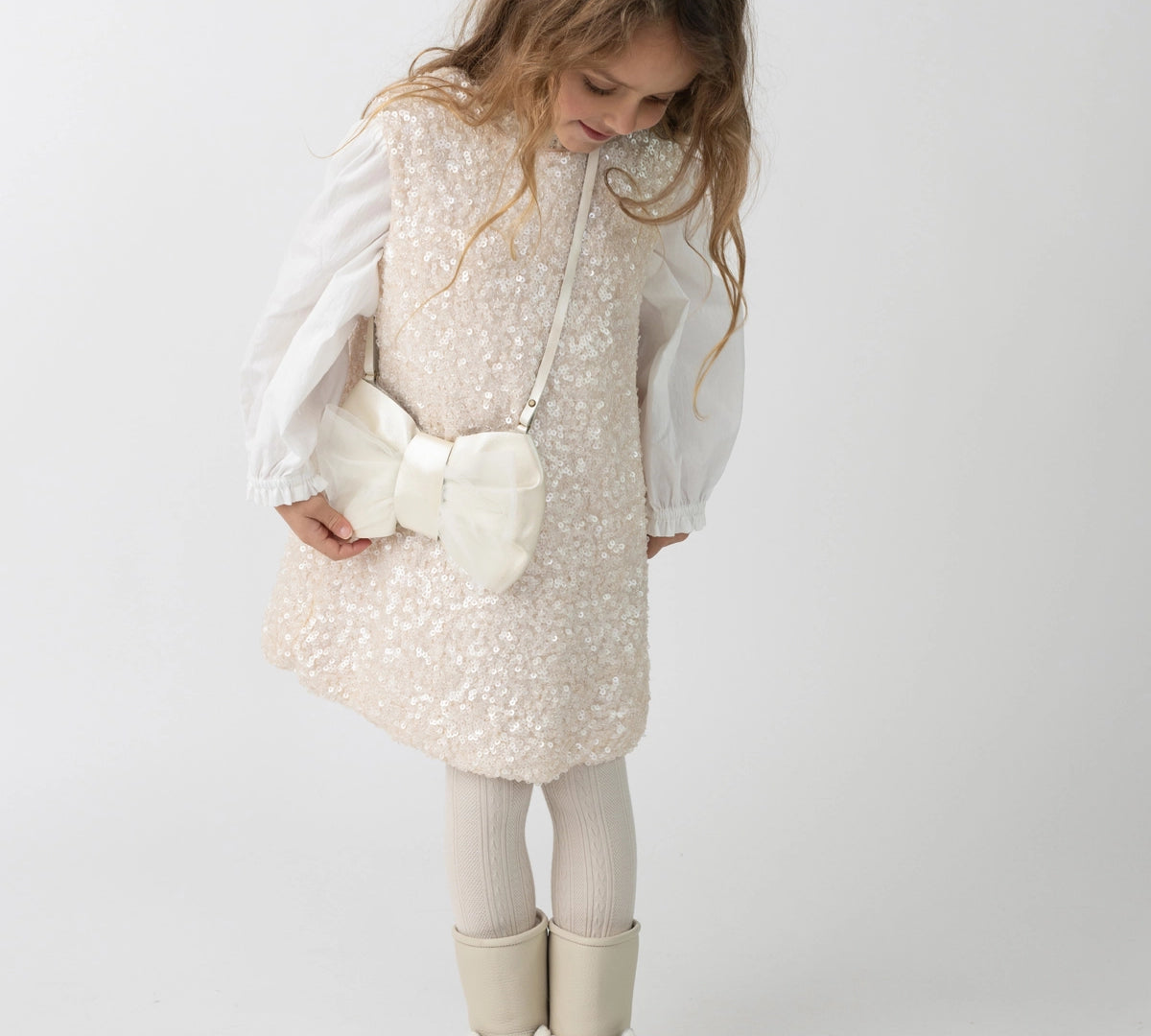 Donsje Lizonne dress in Misty Rose, worn by a child over a white blouse