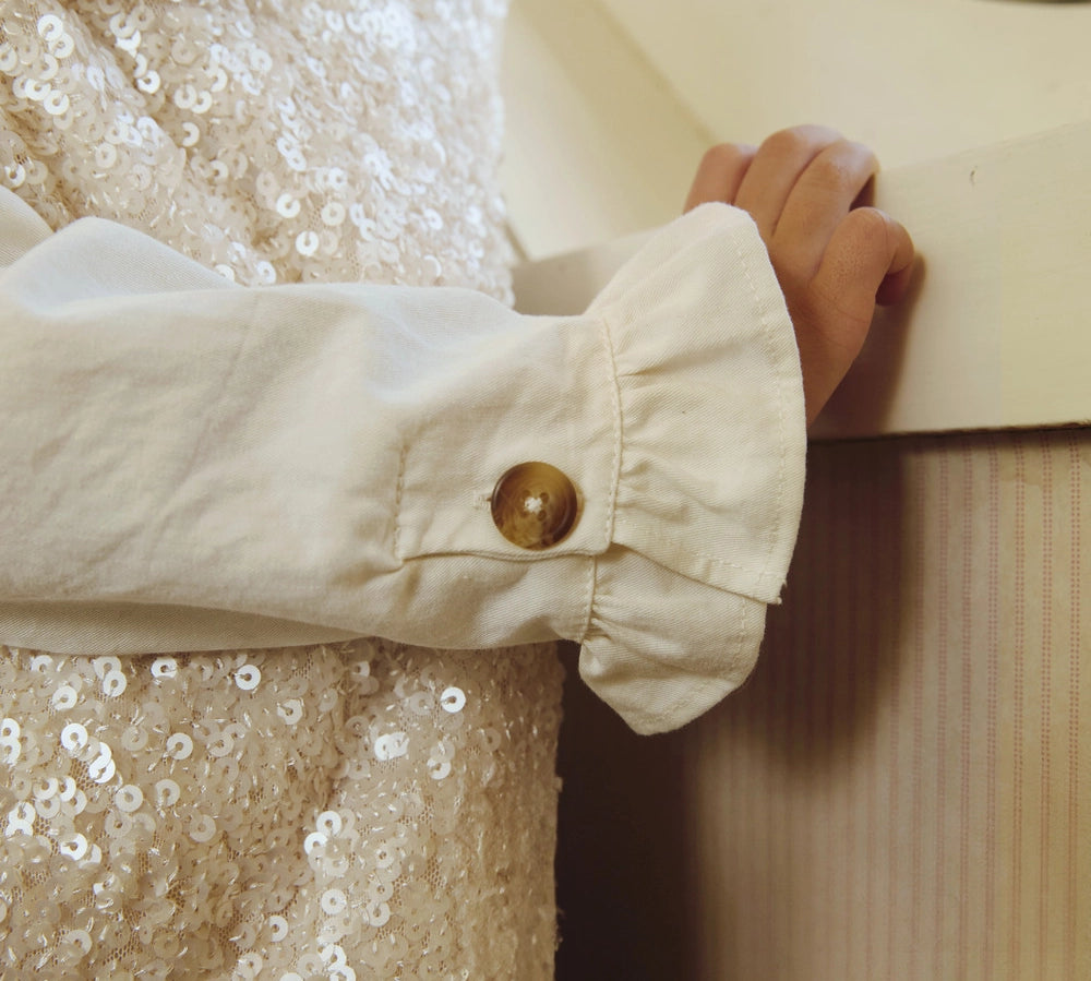 Donsje Lizonne dress in Misty Rose, worn by a child, close-up of the dress