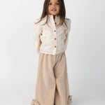 Donsje Opali blouse in Soft Powder with White Blossom, worn by a child with rose trousers