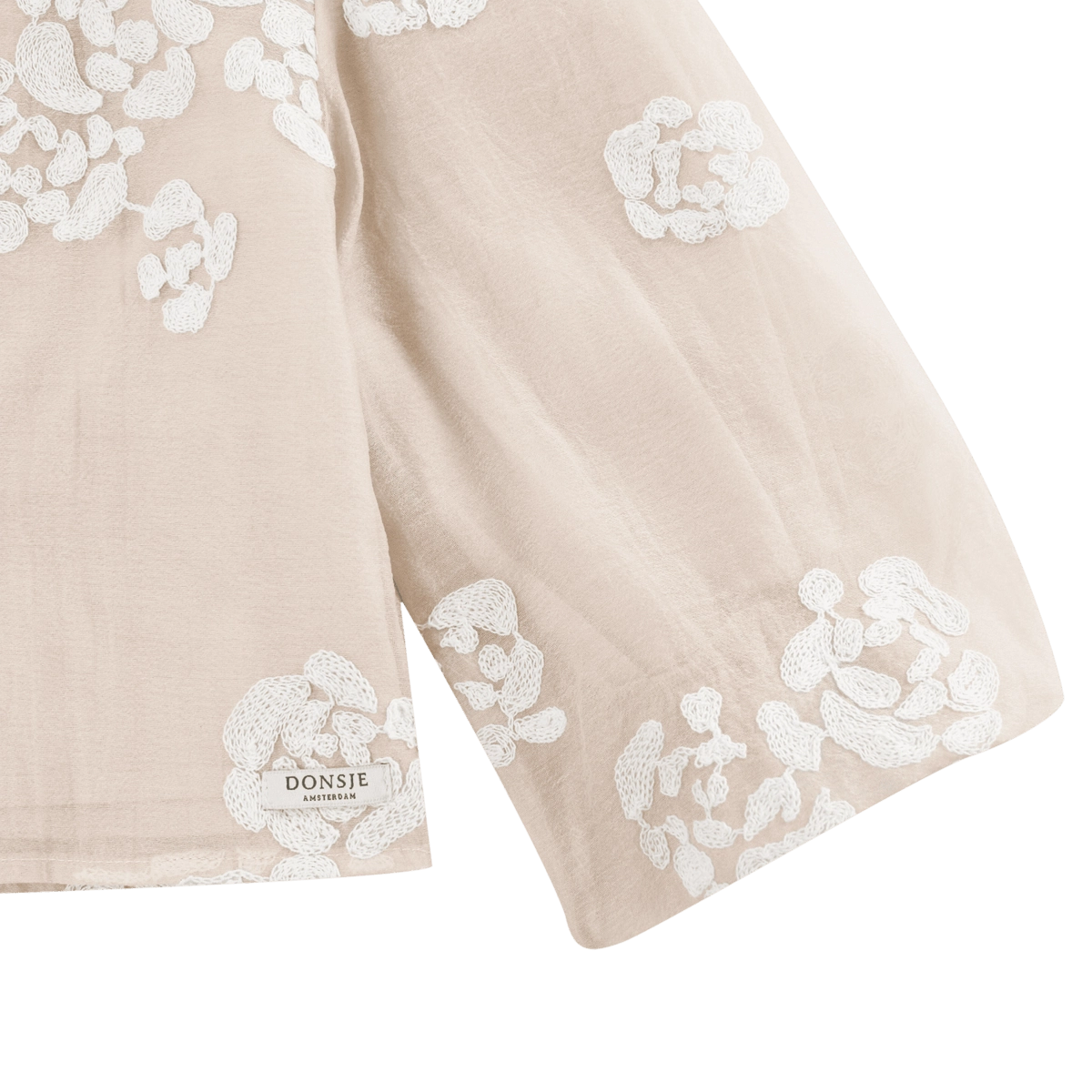 Donsje Opali blouse in Soft Powder with White Blossom, close-up of the floral sleeve and hem