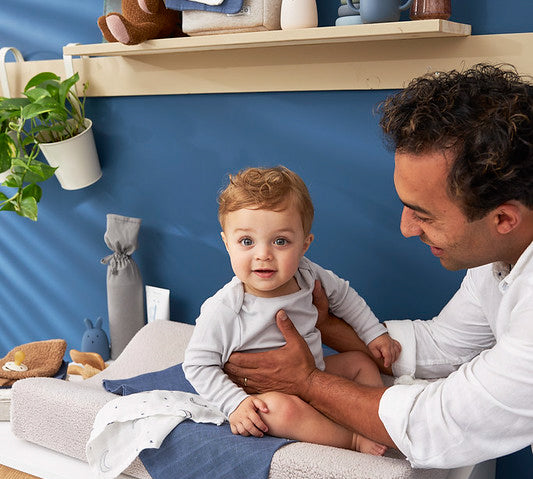 Baby sitting on the Meyco changing pad cover teddy greige color 