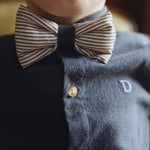 Donsje Zefrin bow tie in Navy and Burgundy Thin Striped, worn by a child with a blue shirt