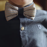 Donsje Zefrin bow tie in Navy and Burgundy Thin Striped, worn by a child with a blue shirt