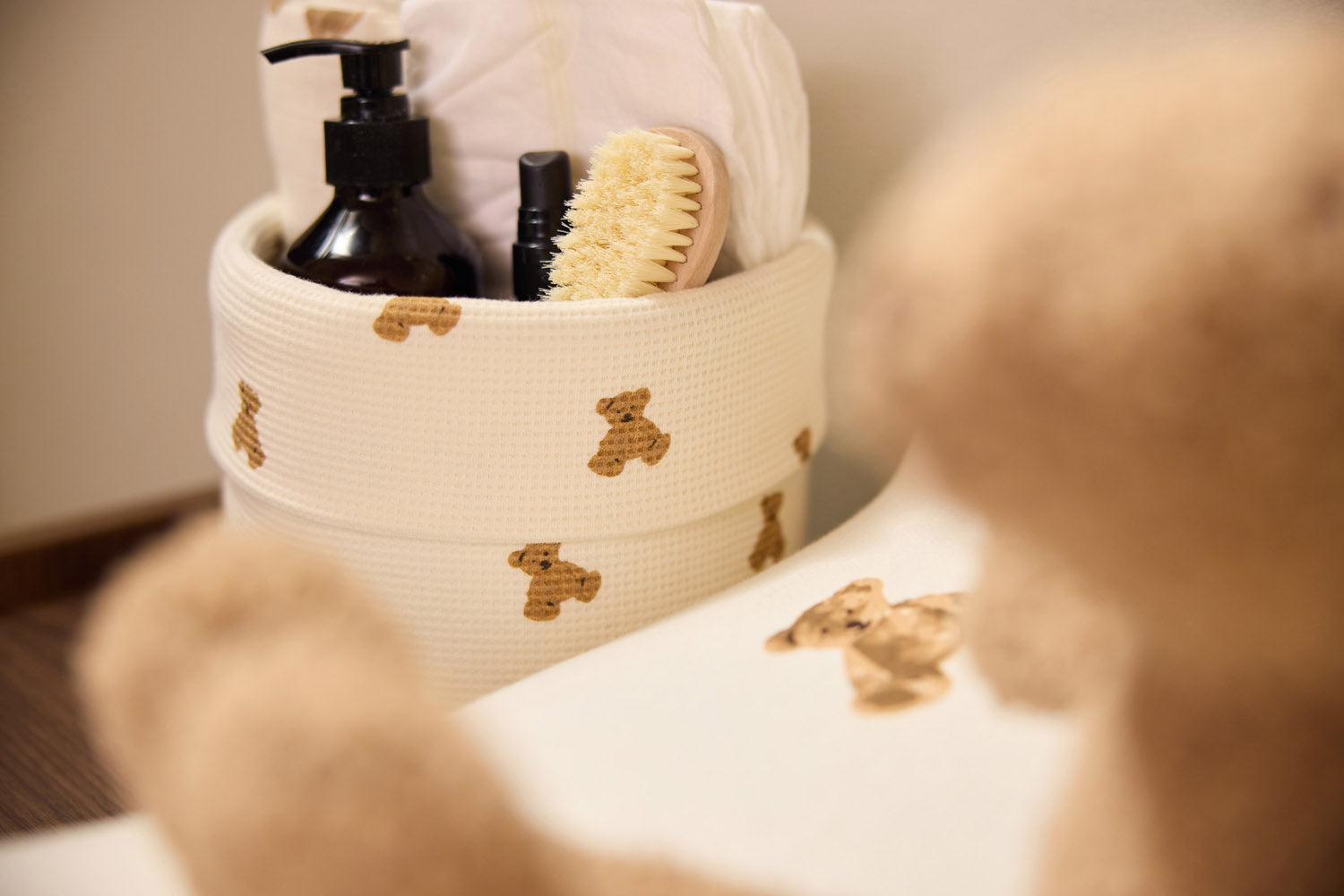 Jollein Little Waffle Mini Teddy Bear basket and Teddy Bear changing-pad cover with a child nearby