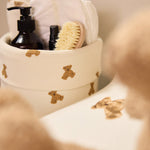 Jollein Little Waffle Mini Teddy Bear basket and Teddy Bear changing-pad cover with a child nearby
