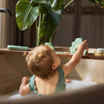 Child reaching toward Jollein Kangaroots bath puzzle pieces from inside a bathtub