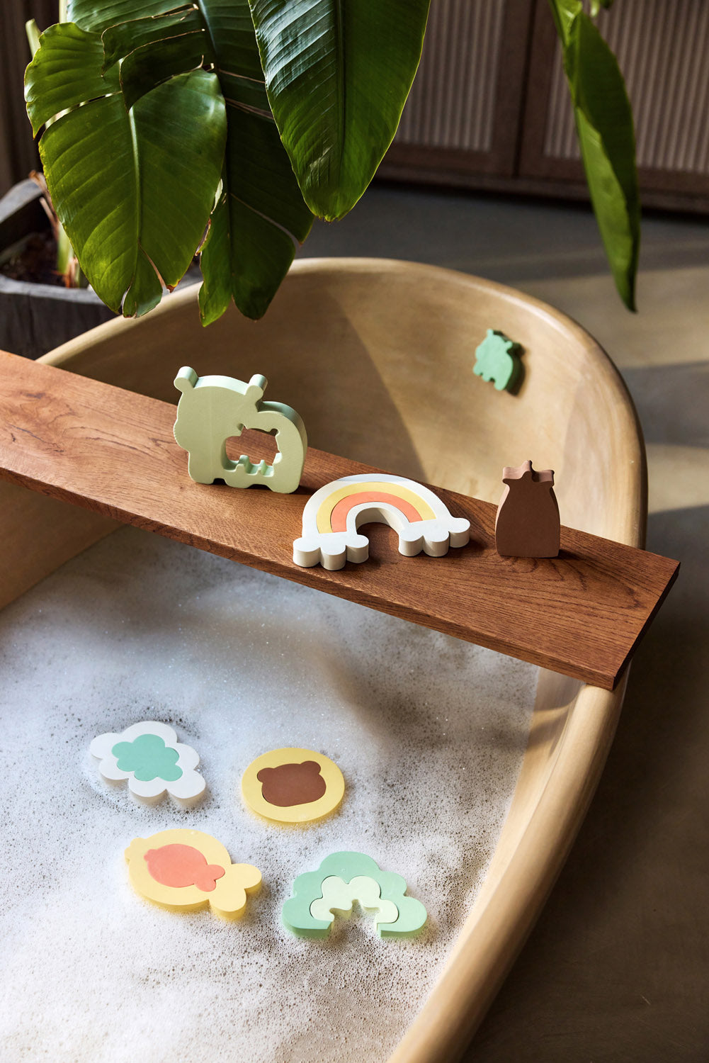 Jollein Kangaroots bath puzzle pieces floating in water and displayed along a wooden bath tray