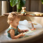 Child holding a figure from the Jollein Kangaroots bath foam playset in a bathtub