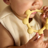 Baby holding the Jollein Vanilla sun silicone teething ring