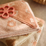 Close-up of the Jollein Coral Rose flower silicone teething ring on pink fabric