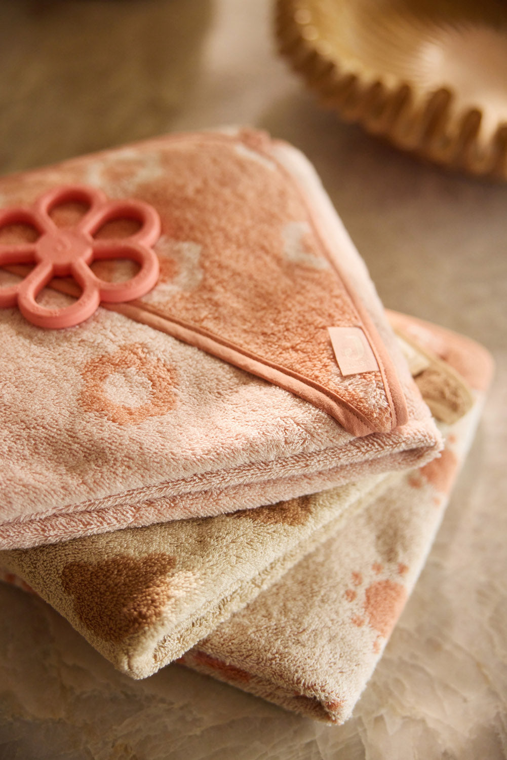 Close-up of the Jollein Coral Rose flower silicone teething ring on pink fabric